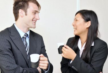 Femme et homme en train de prendre un café en discutant et en riant