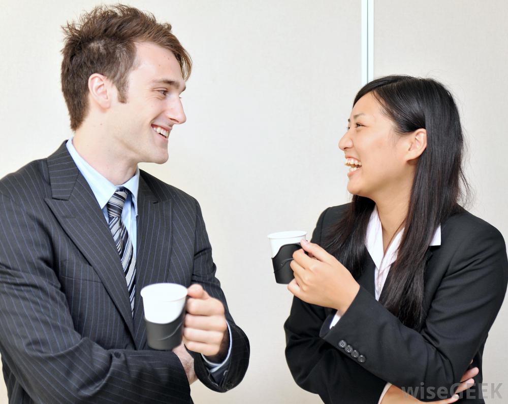 Femme et homme en train de prendre un café en discutant et en riant