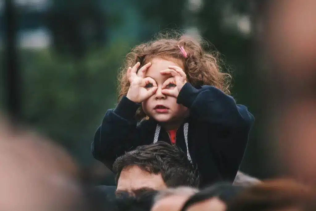Enfant observant au loin avec ses mains en forme de jumelles